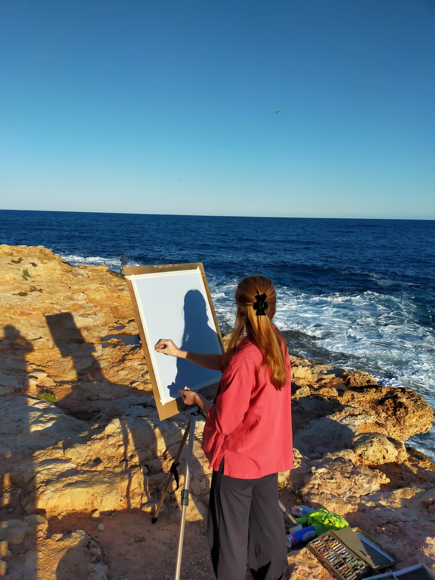Lidia M. Pinzolas dibujando junto al mar